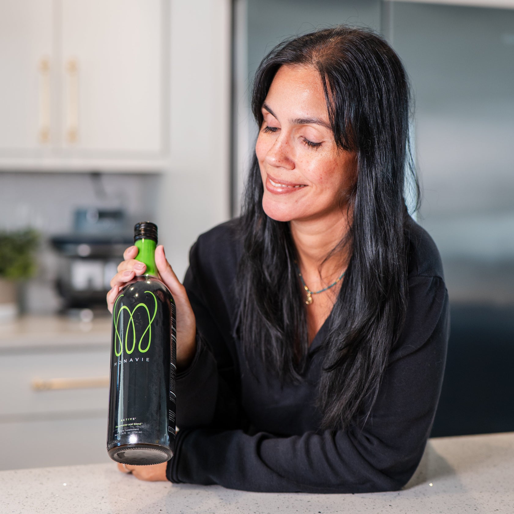 MonaVie Active premium antioxidant liquid blend bottle featured with fresh açaí berries and pomegranate, supporting daily wellness and vitality.