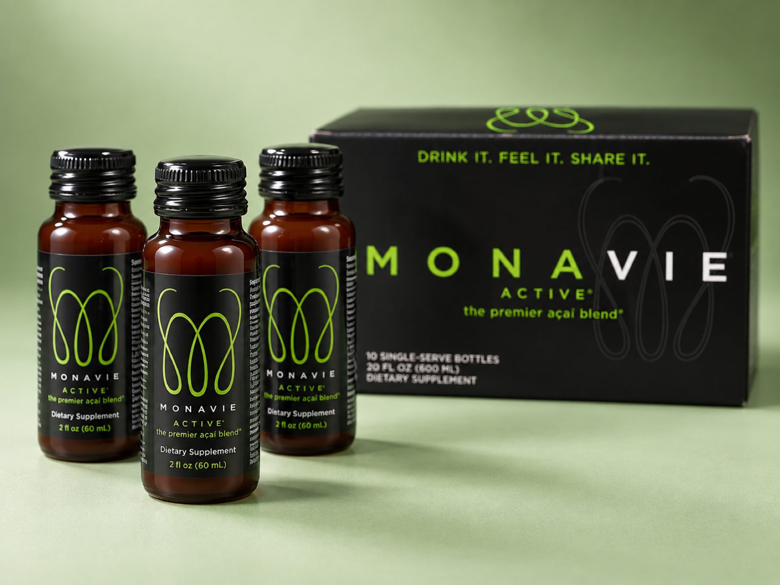 Three MonaVie Active 2 oz shots standing in front of their box