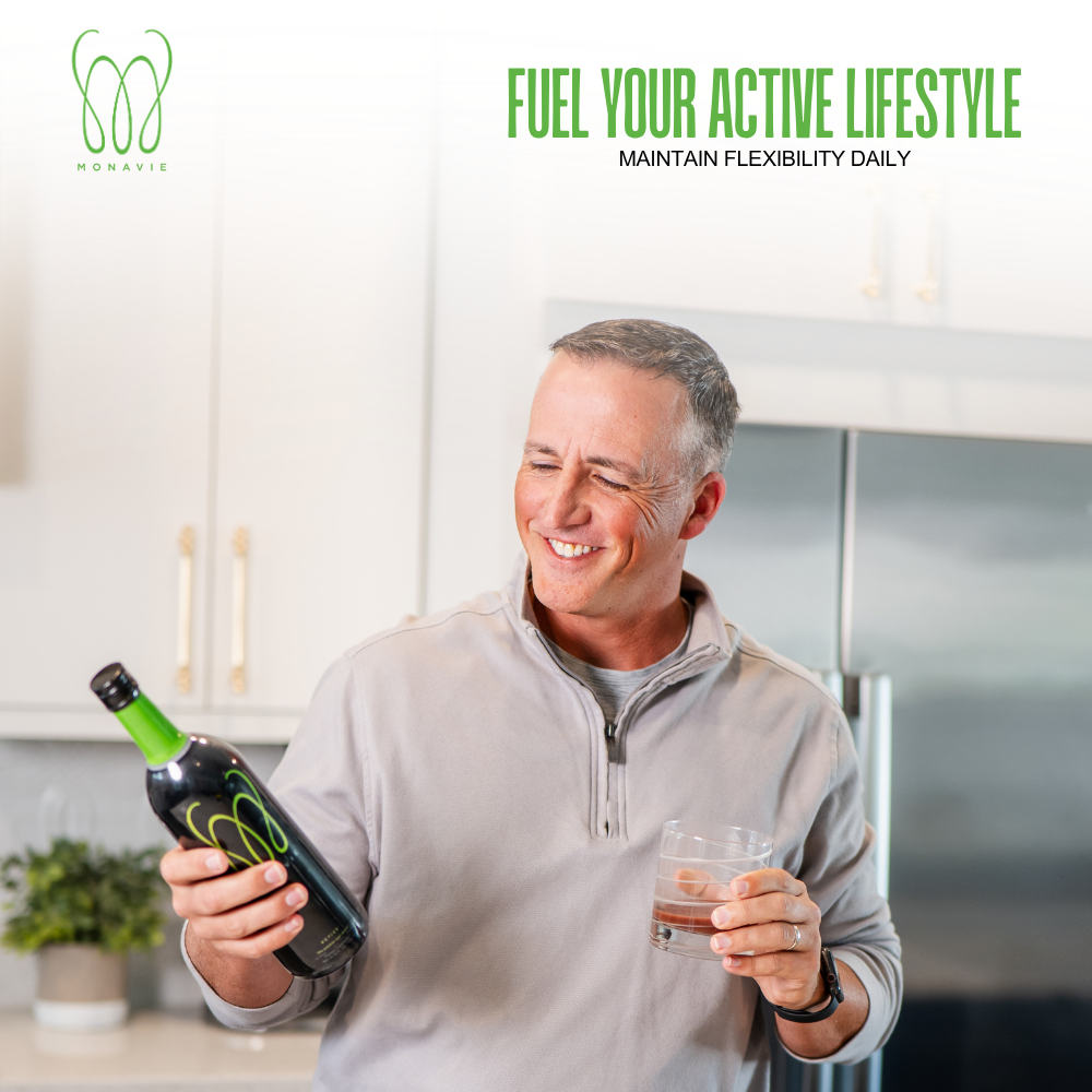 Smiling active man holds a bottle of MonaVie Active nutritional drink in a modern kitchen, featuring a "Fuel Your Active Lifestyle" banner for daily vitality.