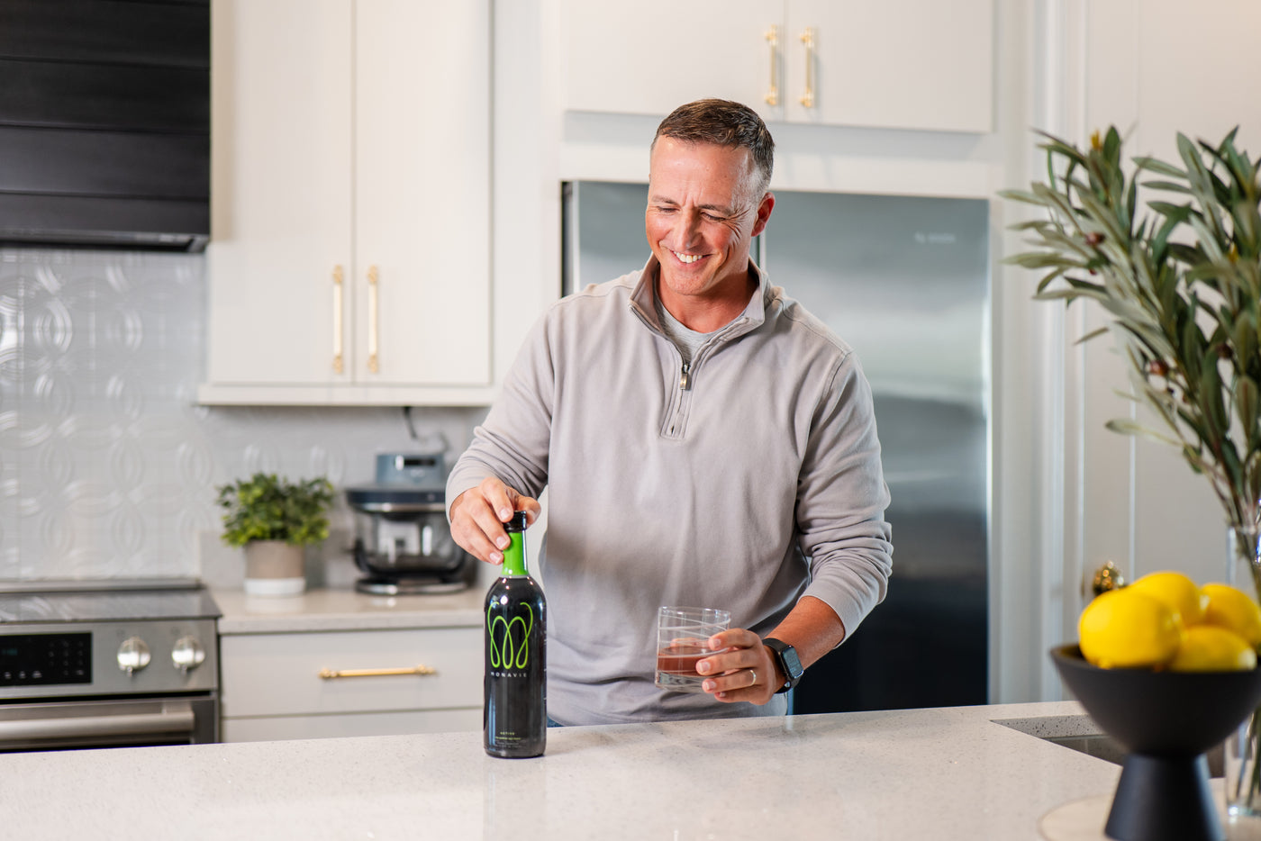 A community event booth for MonaVie Active featuring product sampling and branded materials in a bright, indoor setting.